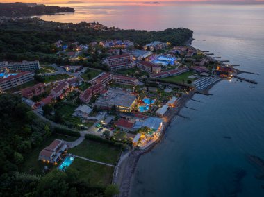 Alacakaranlık, binalar, havuzlar ve sakin okyanusların üzerine yumuşak bir parıltı saçtığı kıyı şeridi boyunca uzanan pitoresk bir tatil köyü. Huzurlu bir kaçış..