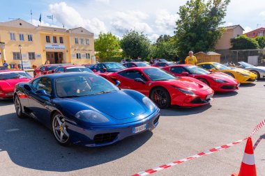 Spor araç çeşitliliği, tasarım ve otomotiv hevesini vurgulayan bir binanın yakınındaki parlak bir gökyüzünün altında park halindedir..