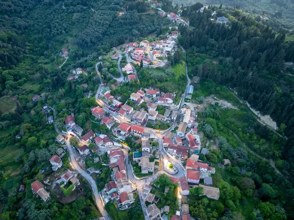 Havadan bakıldığında, kırmızı çatılı binalar, dolambaçlı yollar ve canlı yeşillikleri olan büyüleyici bir köy görülüyor. Sahne huzuru çağrıştırıyor.