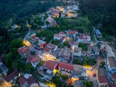 Yüksek açılı çekimde, konforlu evleri, yeşil bitki örtüsü ve dolambaçlı yolları olan tuhaf bir köy, alacakaranlık saatinde çekilen pitoresk bir manzarayla gözler önüne seriliyor..