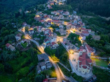 Resmedilmeye değer bir köy, yemyeşil bir yamaçta, alacakaranlık çöktüğünde sıcak ışıklarla parıldıyor, sakin ve davetkar bir atmosfer yaratıyor..