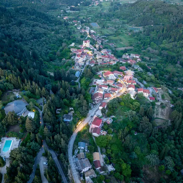 Hava perspektifi, yoğun bir orman manzarasıyla çevrili kırmızı çatılı evleri ve kilisesi olan büyüleyici bir Avrupa köyünü yakalıyor..