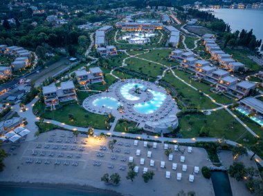 Hava görüntülerinde, eşsiz şekilli, aydınlık bir havuzu, villaları ve alacakaranlıkta sıralanmış güneş pansiyonlarıyla muhteşem bir sahil beldesi sergileniyor..