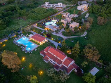 Havadan çekilen görüntüler, aydınlık havuzları ve yemyeşil köşkleriyle çevrili, alacakaranlıkta ya da şafak vakti çekilmiş sakin bir tatil köyü sunuyor..