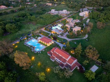 Yükseltilmiş bir perspektif güzel villaları, yüzme havuzlarını ve sakin bir yerdeki lüks otellerin yeşil manzaralarını gösteriyor..