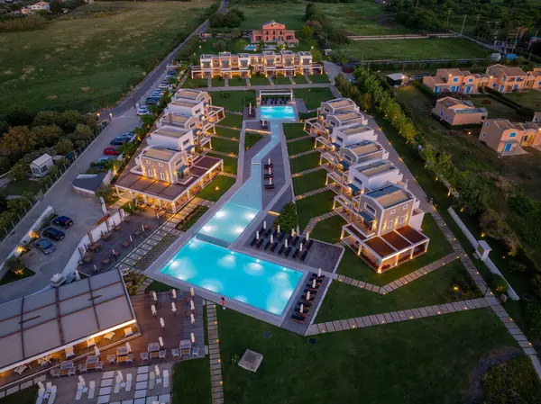 Hava perspektifinde modern binalar, çoklu yüzme havuzları, manikürlü çimenler ve zarif açık hava manzaraları sergileniyor..