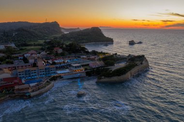 Büyüleyici bir hava manzarası, sakin binaların gün batımında çalkantılı denizle buluştuğu sahile tutunarak bir cennet oluşturan villaları yakalıyor..