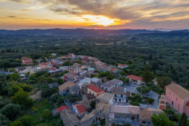 Büyüleyici bir köy gün batımının sıcacık parıltısıyla yıkanır. Yoğun, yeşil tepeler ve canlı bitki örtüsüyle çevrilidir.. 