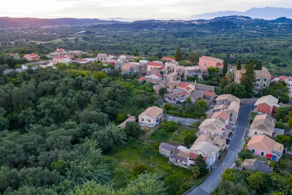 Bu hava, yoğun yeşillikler ve yumuşak bir gökyüzünün altında uzak dağlarla çevrili geleneksel mimarisi olan küçük bir köy yakalıyor..