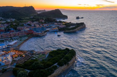 Bu, çarpıcı bir günbatımında ya da okyanus üzerinde canlı renklerle gün doğumunda oteller, uçurumlar ve yemyeşil bir kıyı kasabasını yakalar..