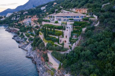 Etkileyici bir sahil arazisi, çarpıcı denize bakan yemyeşil bir yamaçta kurulmuştur. Mimari doğayla kusursuz bir şekilde harmanlanır..