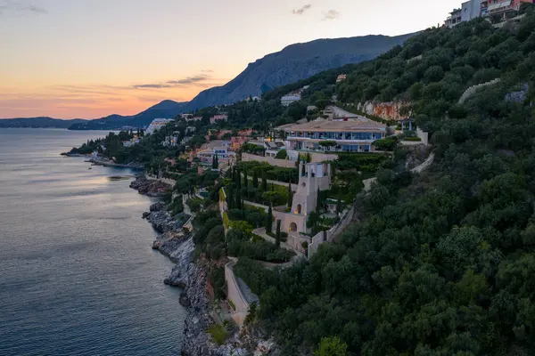 Alacakaranlık saatlerinde, güzel bir Avrupa kasabasında yeşil bitki yaşamı ile çevrili bir uçurum kenarına bir dizi villa yerleştirilmiştir..