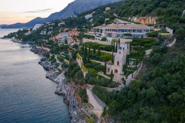 Uçurumun kenarında kulesi olan lüks bir malikane var. Huzurlu okyanus ve tepe tepe arkaplan manzaranın dingin güzelliğine eklenir.