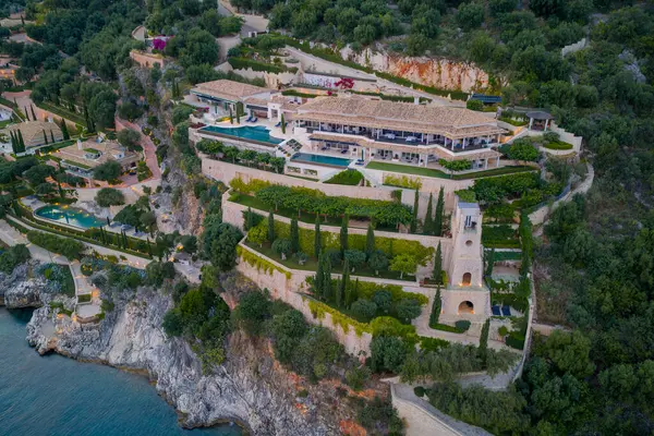 Teraslı bir yamaçta lüks bir villa, havuzlar ve yemyeşil bahçeler, doğal güzellik ve tepe kenarı cazibesiyle lüks mimariyi birleştiriyor..