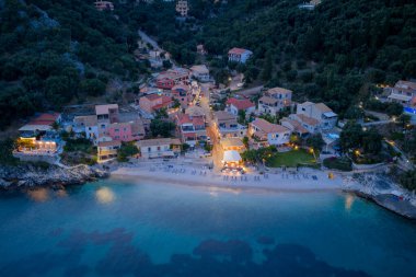 Alacakaranlık, büyüleyici evleri, kumlu plajı ve sakin denizi olan yeşil tepelerin olduğu bir sahil köyünü aydınlatır..