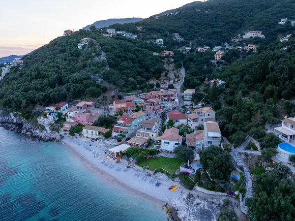 Canlı bir sahil köyünün havadan görünüşü, yemyeşil bir yamaçla dingin bir turkuaz deniz arasına kurulmuş renkli binalar ve huzurlu plajlar..