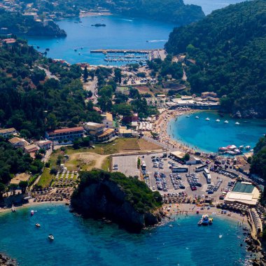 Paleokastritsa 'nın Korfu, Yunanistan' daki ünlü çifte hangarının yüksek hava aracı manzarası. Kalabalık plajları, büyük bir otoparkı ve güzel mavi bir marinası olan popüler bir yaz tatili merkezi.