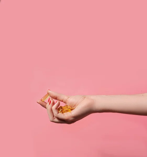 Vrouwelijke Hand Met Veel Olie Capsules Roze Achtergrond Welzijnsconcept — Stockfoto