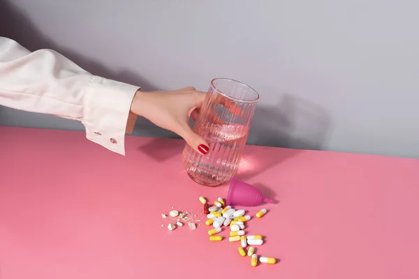 Kobieta Wkłada Szklankę Wody Garść Tabletek Kubek Menstruacyjny Stole Koncepcja — Zdjęcie stockowe