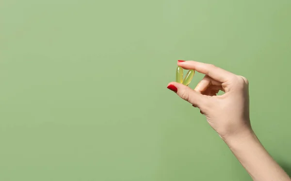 Женщина Держит Две Капсулы Масла Зеленом Фоне Концепция Благополучия Стоковое Фото