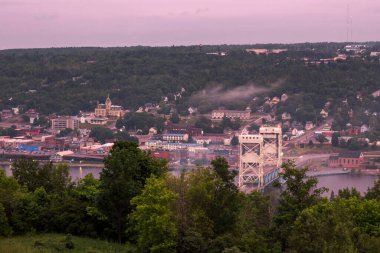 Bulutlu bir yaz günbatımında portage kanal kaldırma köprüsüne ve Houghton Michigan 'a bakan yüksek açılı bir çekim..