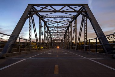 Düşük açılı bir alacakaranlık görüntüsü. Bir sonbahar akşamı eski Cedar Bulvarı yaya köprüsünün uzun pozu.
