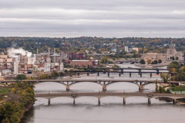 Bulutlu bir sonbahar gününde sedir nehri boyunca uzanan köprülerin telefoto görüntüsü.