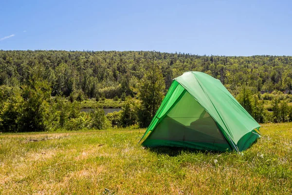 a green tent at the trails end campsite in copper harbor michigan on a clear summer day