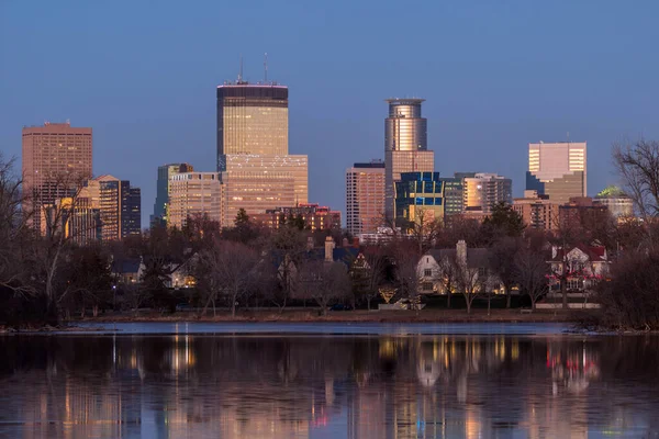 Minneapolis 'in günbatımından hemen sonra adaların gölündeki ince buza yansıyan kış telefoto çekimi..