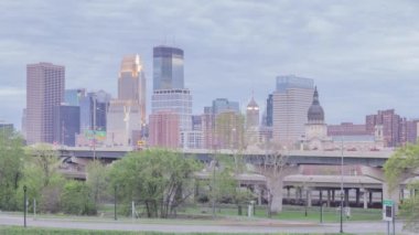 Bulutlu Alacakaranlık 4K Zaman Çizelgesi sırasında Önplan Trafikli Minneapolis Skyline Mimarisinin Orta Çekimi