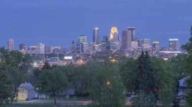 Alacakaranlık 4K Zaman Çizelgesi 'nde Yeşil Ağaçların Üzerinde Yükselen Minneapolis Şehir Manzarası Altında Uzun Pozlu Şehir Sokak Trafik Geçitleri