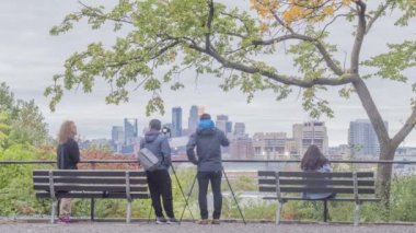 Yakın plan Sıkıştırma Fotoğrafçıları, 4K Timelapse 'deki bir Sonbahar Alacakaranlığı sırasında Minneapolis Şehri' nin Prospect Park Vista 'sının fotoğraflarını çekiyor
