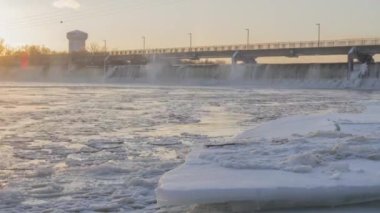 Sunset 4K Timelapse 'deki Icy Mississippi Nehri üzerinde Rakun Rapids Barajı ve Brooklyn Park Su Kulesi' nin Kış Çekimi