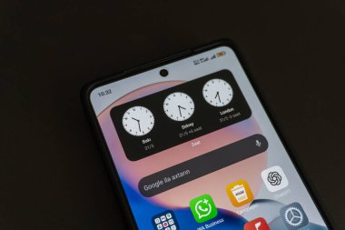 Beyaz arkaplanda cep telefonu ve alarm saati, kapatın.