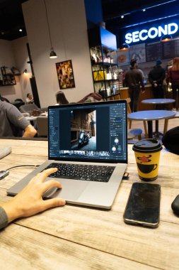 Bilgisayarda çalışan erkek fotoğrafçı ve ofiste dizüstü bilgisayar.