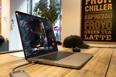 Kahve fincanını dizüstü bilgisayarlı ve ahşap masadaki akıllı telefonlu kapat.