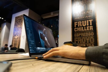 Mutfakta dizüstü bilgisayarı olan genç bir adam.