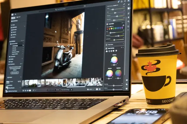 Tahta bir masada bir fincan kahve ile dizüstü bilgisayar..