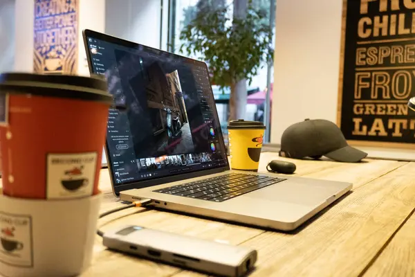 Diz üstü bilgisayarı ve bir fincan kahvesi olan bir kafeterya.