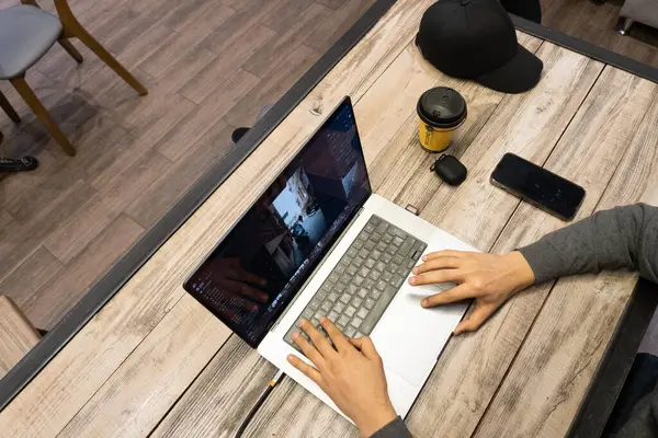 Ofiste dizüstü bilgisayarda çalışan genç adam.