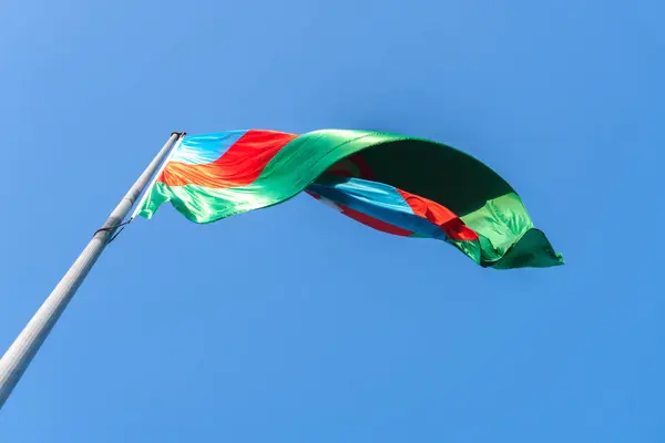 Mavi gökyüzünde Azerbaycan bayrağı sallıyor. Bakü, Azerbaycan. 8 Haziran 2025.