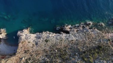 Sert ve kayalıklı sahildeki tenha sahilin havadan görüntüsü.
