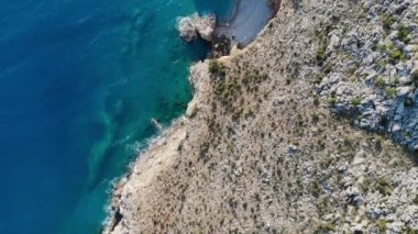 Sert ve kayalıklı sahildeki tenha sahilin havadan görüntüsü.