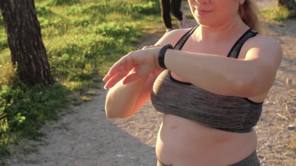 Young Size Woman Using Fitness Tracker While Jogging Outdoors — Stock Video