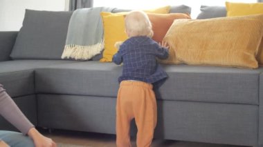 Küçük bebek ayakta durmayı ve yürümeyi öğreniyor.