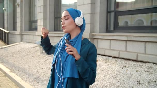 Nahöstliche Frau Hidschab Hört Musik Mit Kopfhörern Und Tanzt Freien — Stockvideo