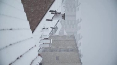Çatıları olan şehrin üzerinde şiddetli kar yağışı