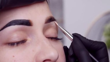 Genç bayan kaş bakımını yakından yapar.