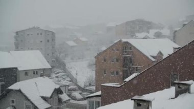 Çatıları olan şehrin üzerinde şiddetli kar yağışı