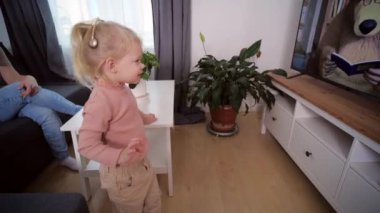 Koklear implantı olan bir kız televizyon izler ve sesler duyar.